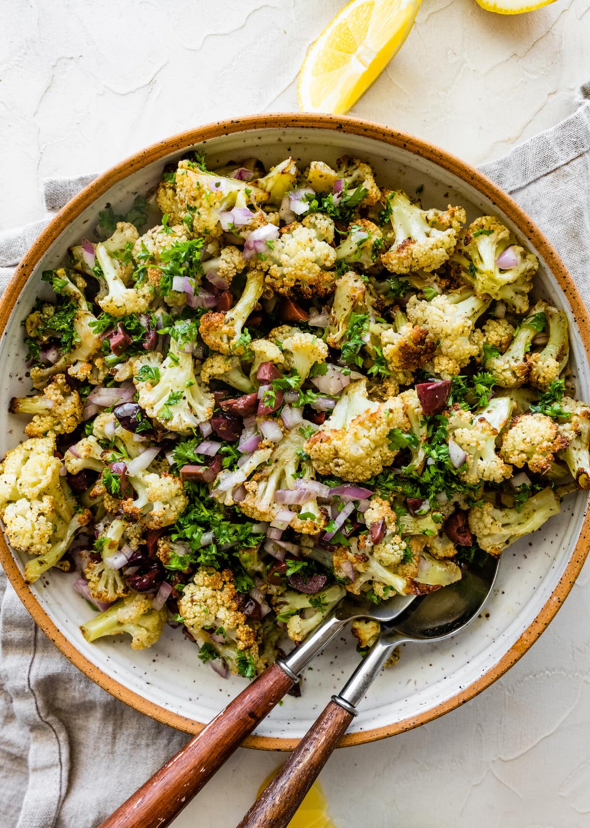 Roasted Cauliflower Salad in a large bowl with serving spoons.