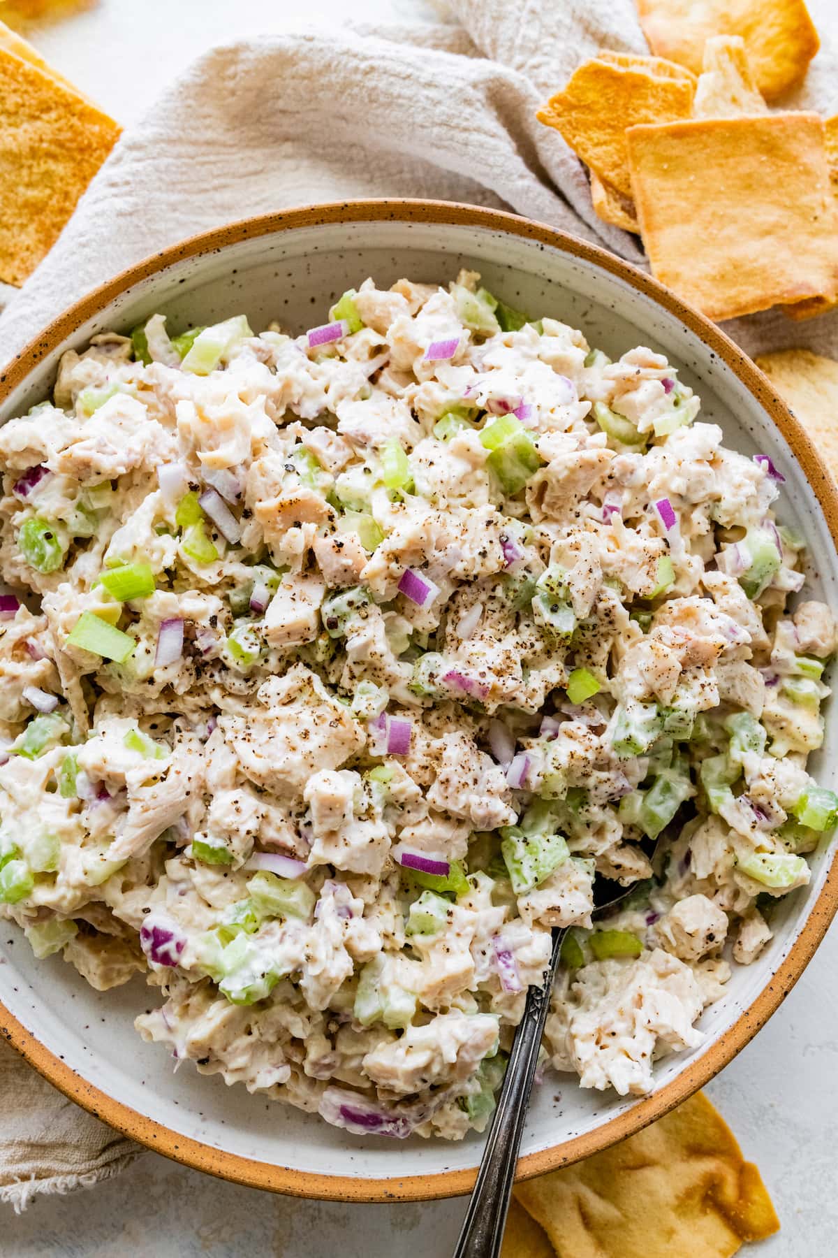 Rotisserie chicken salad on a plate with a metal spoon.