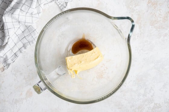 A glass bowl with a block of butter and vanilla extract.