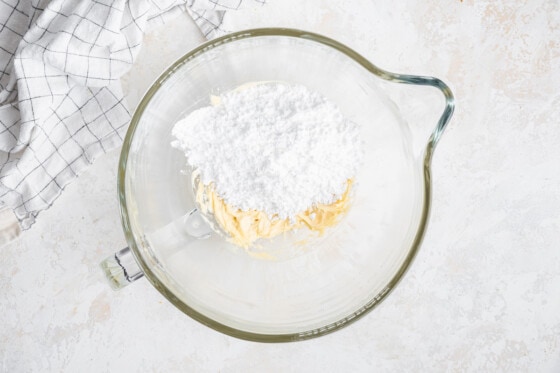 Powdered sugar in a glass bowl with butter and vanilla.