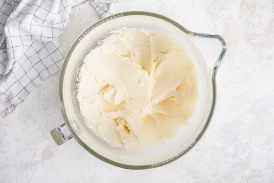 A glass bowl with butter, vanilla, and powdered sugar mixed well.