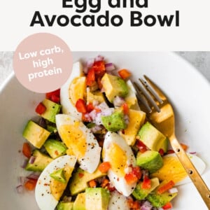 Chopped hard boiled eggs, peppers, onion and avocado in a bowl.