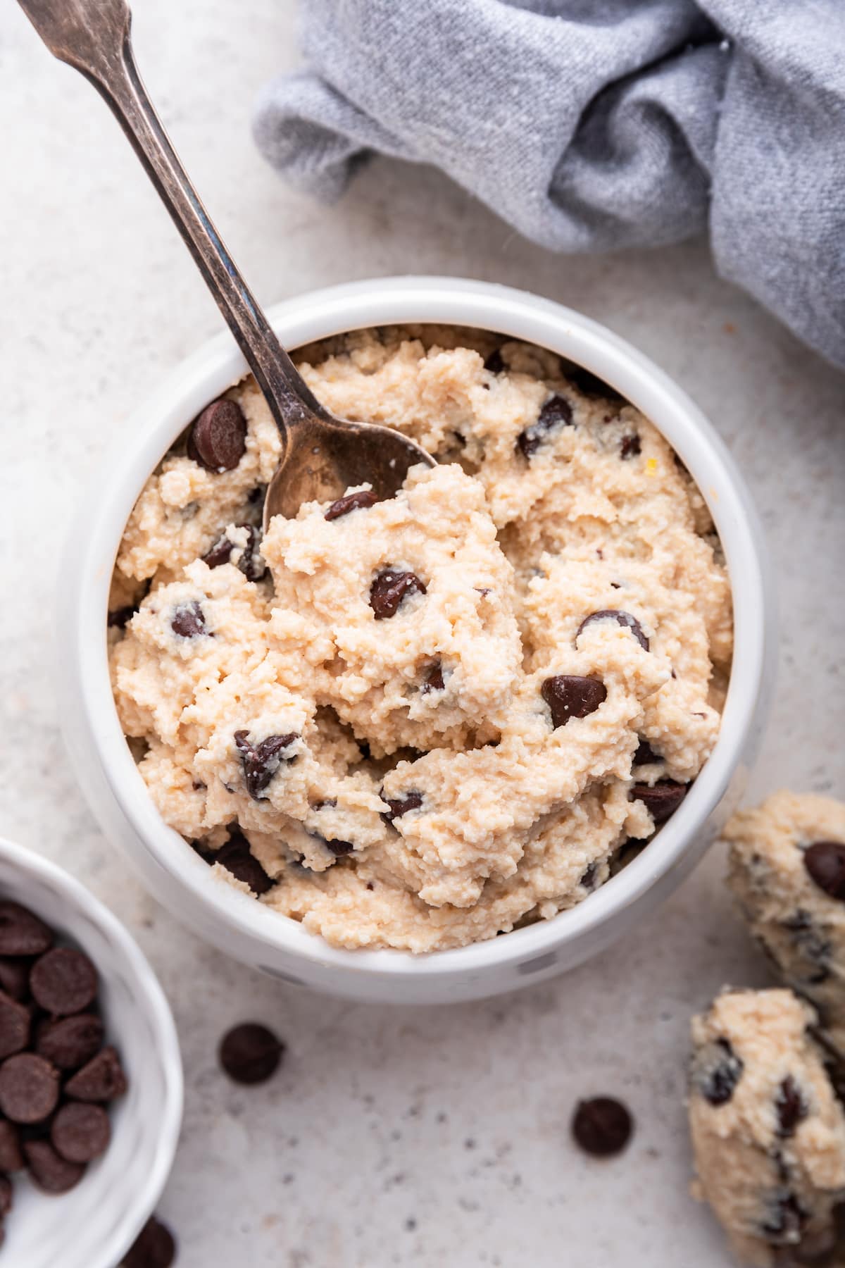 A spoon in a small bowl of cottage cheese cookie dough.