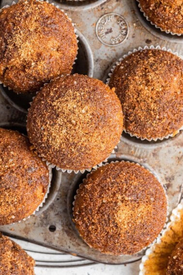 Sweet potato muffins in and around a muffin tin.