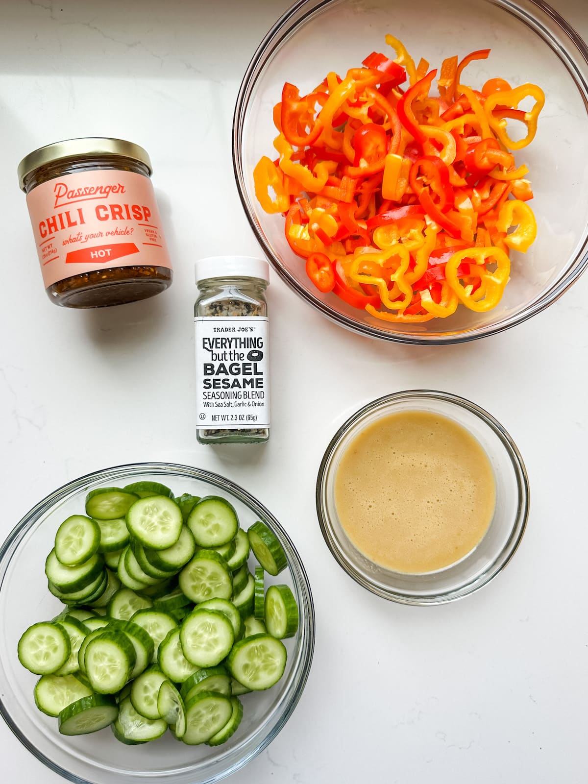 Ingredient shot with cucumber, bell pepper, chili crisp, everything bagel seasoning and sesame ginger dressing.