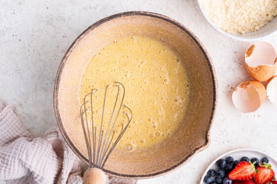 The wet ingredients for the smash cake combined in a mixing bowl with a whisk.