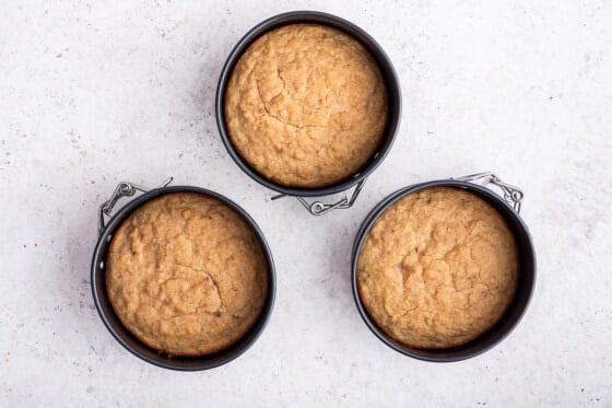 Three 4" round pans with smash cake batter in them after they've been baked.