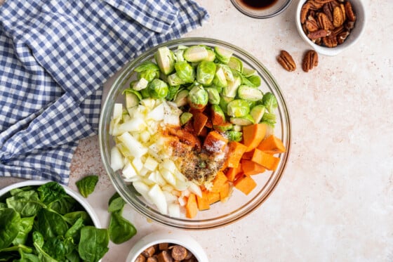 All the vegetables and spices for the sweet potato hash in a large mixing bowl before being baked.