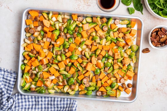 All the vegetables and sausage for the sweet potato hash on a baking tray before being baked.