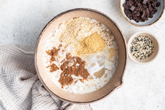 All the ingredients, except for the chocolate chips, in a large mixing bowl being prepared to make the tahini baked oatmeal.