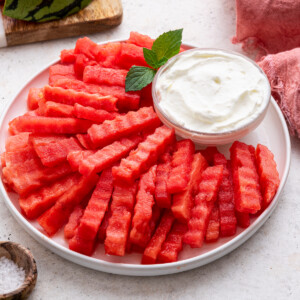 A plate of watermelon fries served with a yogurt dip.