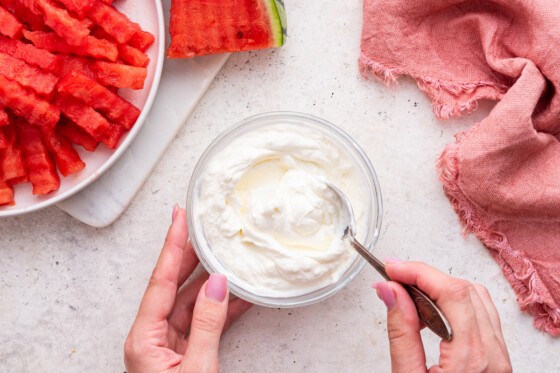 Woman's hands mixing the yogurt dip.