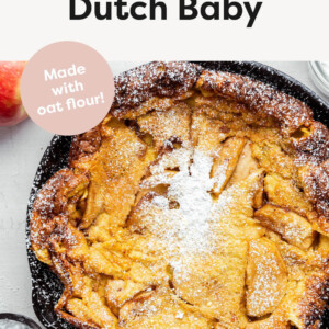 Apple Dutch Baby in a cast iron skillet with powdered sugar on top.