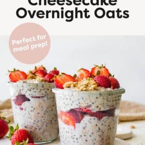 Strawberry cheesecake overnight oats in jars and layered with graham cracker crumbs and sliced strawberries.