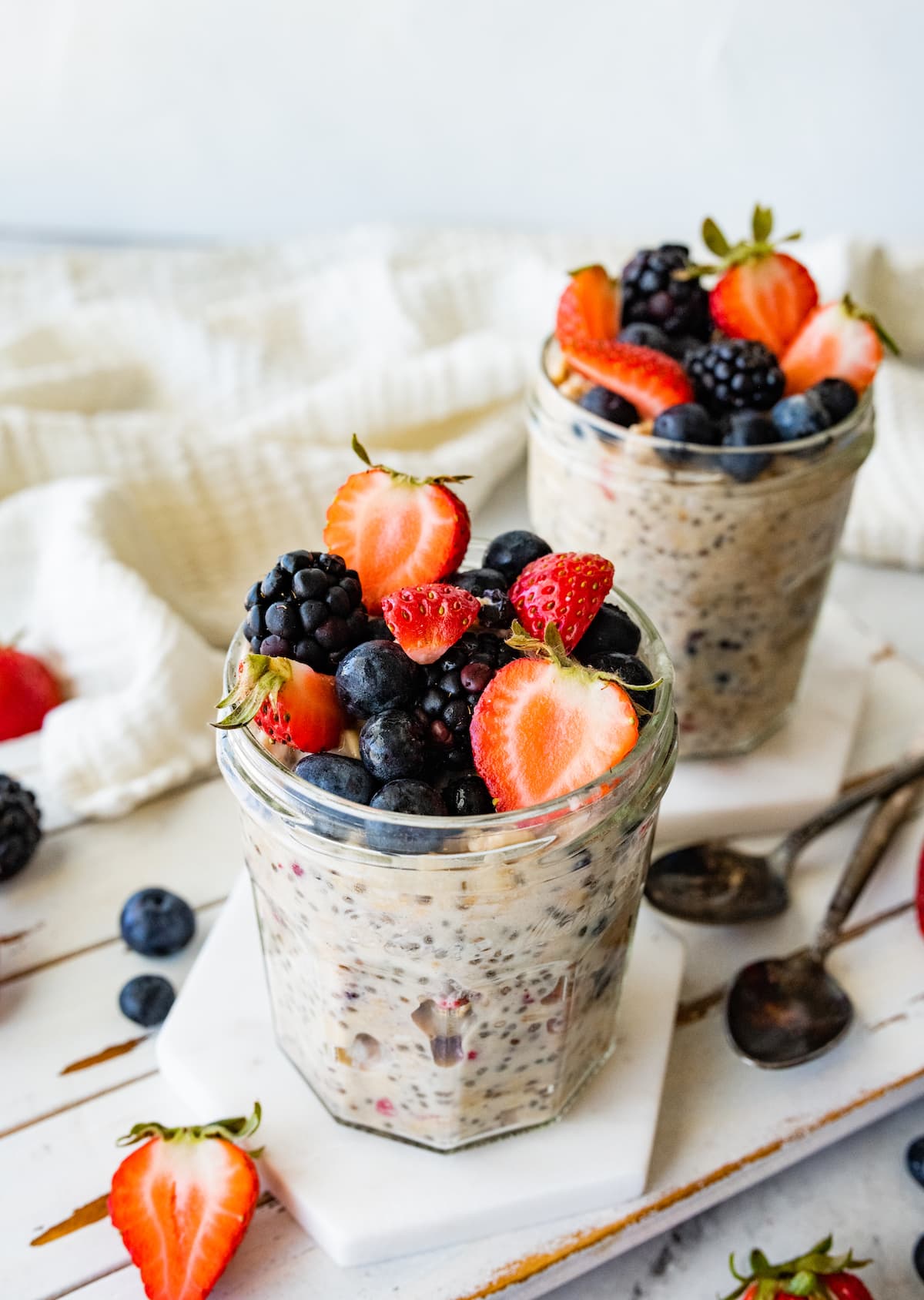 Two mason jars with cottage cheese overnight oats and topped with fresh berries.