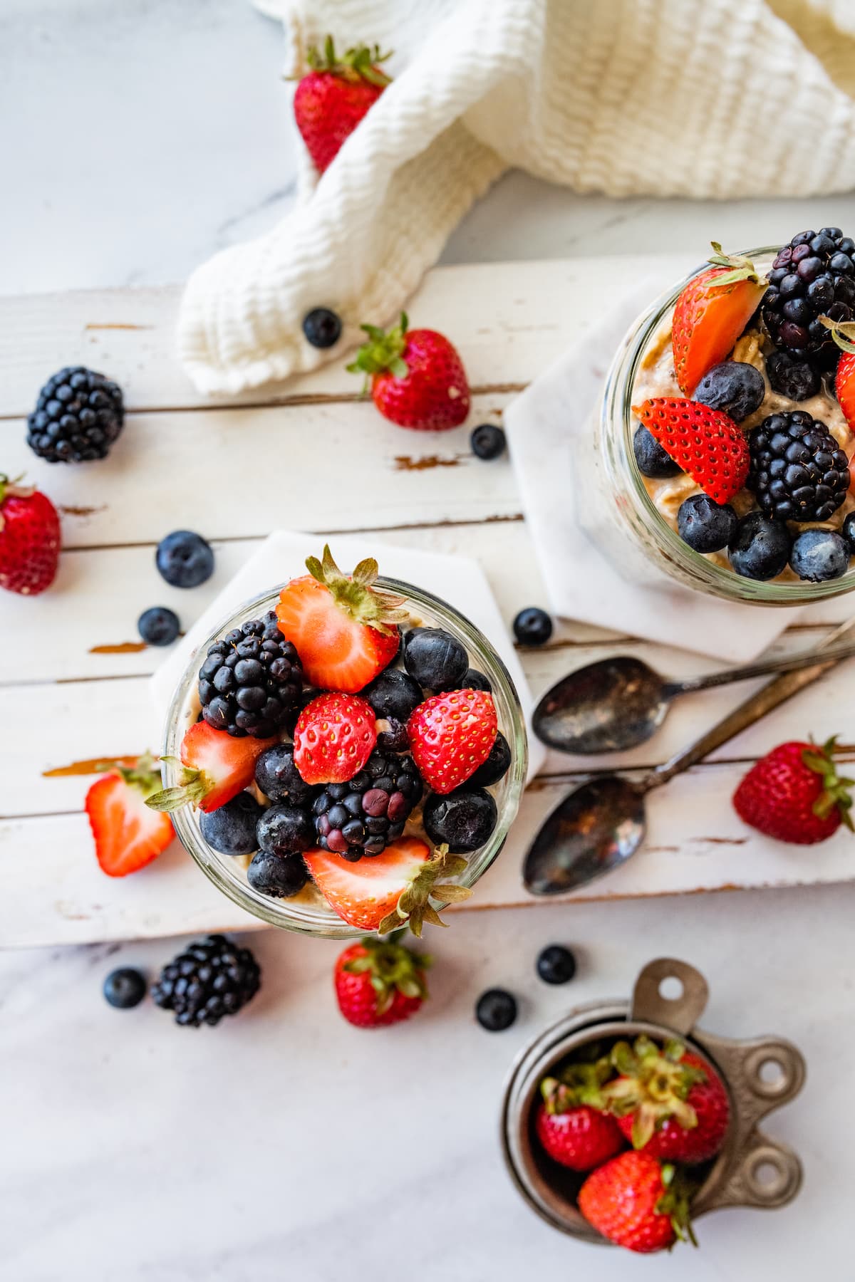 Two mason jars with cottage cheese overnight oats and topped with fresh berries.