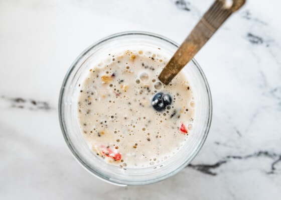 A mason jar with all the ingredients for the cottage cheese overnight oats before being soaked overnight.