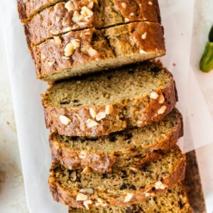 Healthy zucchini bread slices on a wooden cutting board.