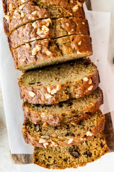 Healthy zucchini bread slices on a wooden cutting board.