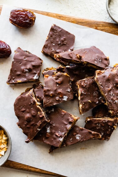 Multiple pieces of date bark on parchment paper.