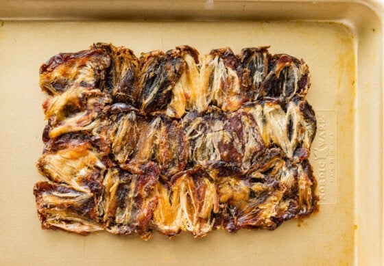 Multiple dates flattened out into a rectangle on a metal baking dish.