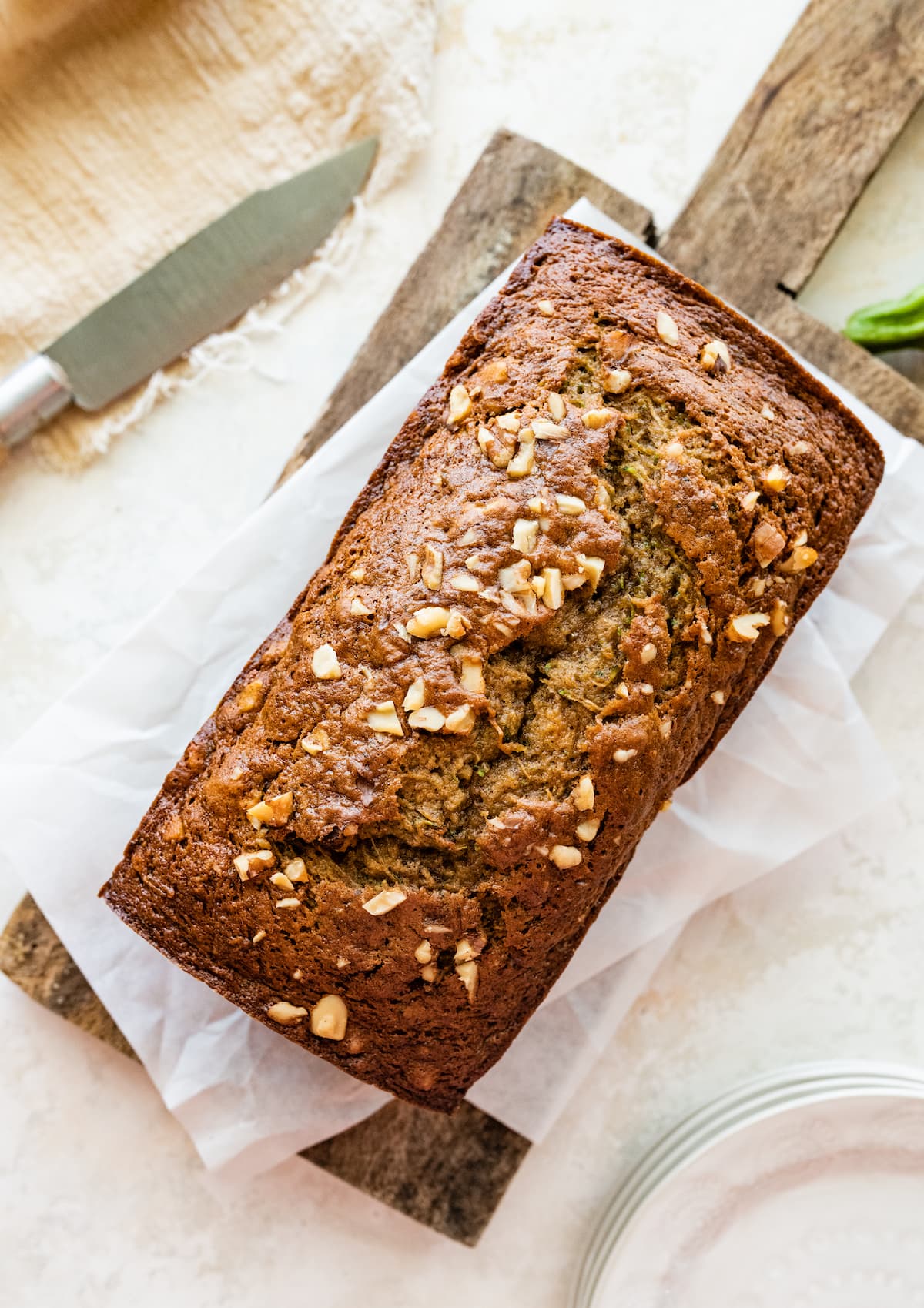 A loaf of healthy zucchini bread on a wooden cutting board.