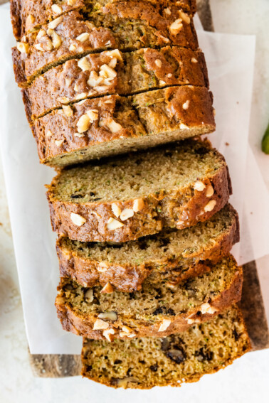 Healthy zucchini bread slices on a wooden cutting board.