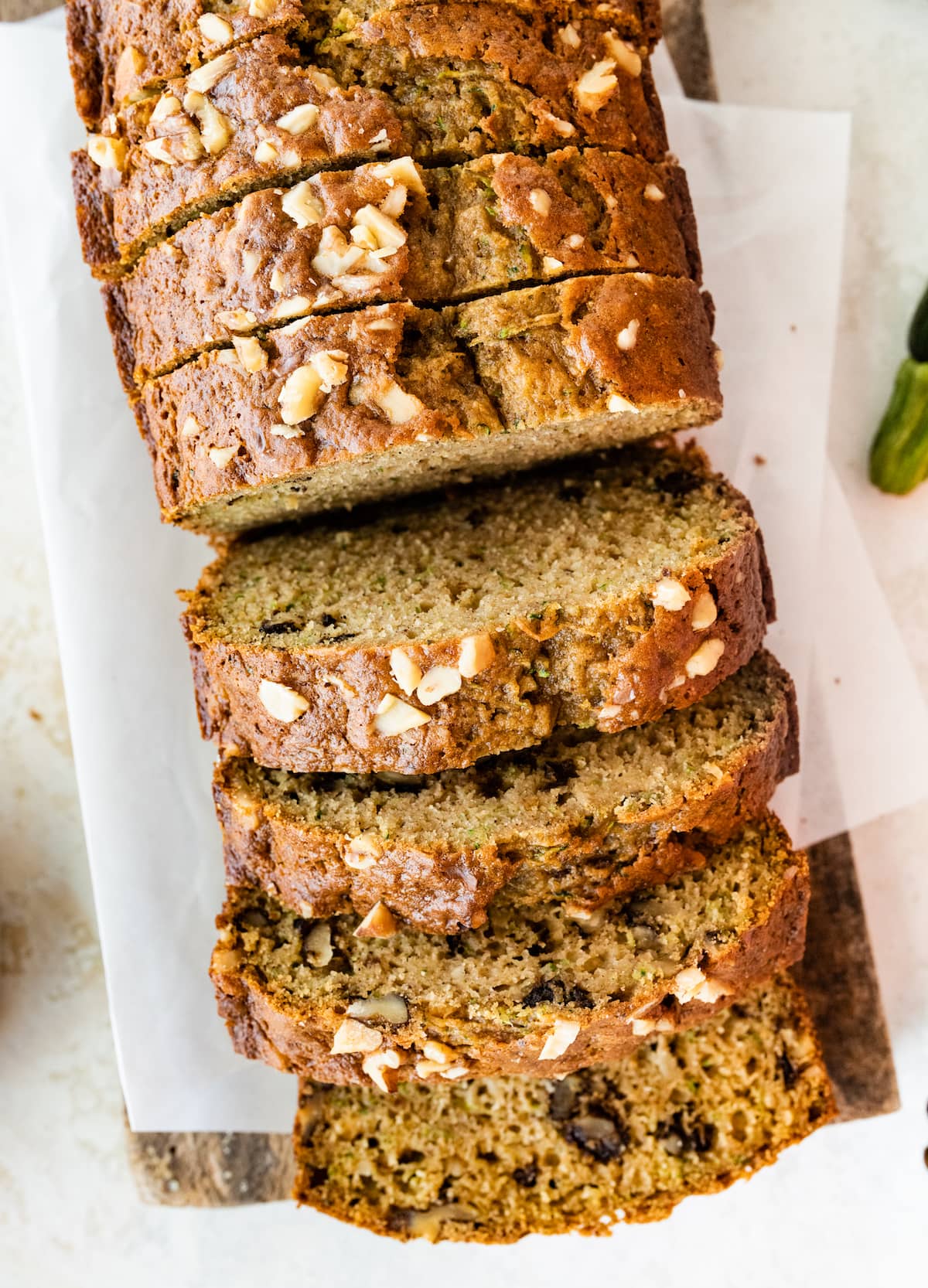 Healthy zucchini bread slices on a wooden cutting board.