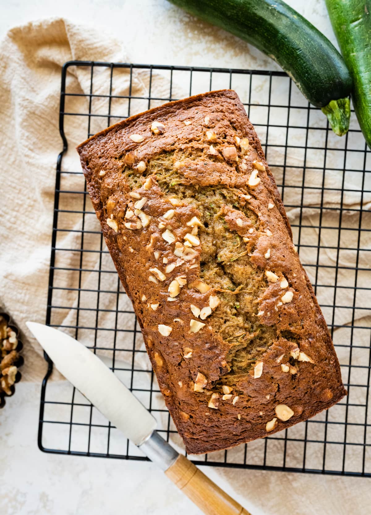 A loaf of healthy zucchini bread on a wire rack.