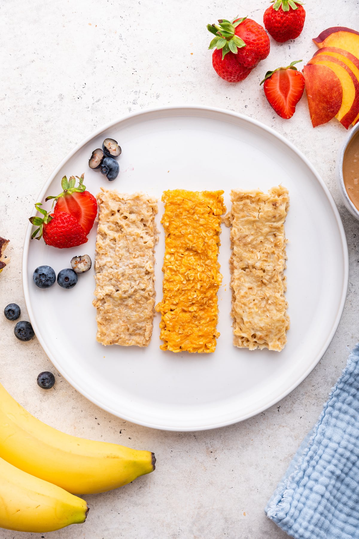 Three oatmeal fingers (banana, sweet potato and applesauce) on a white plate.