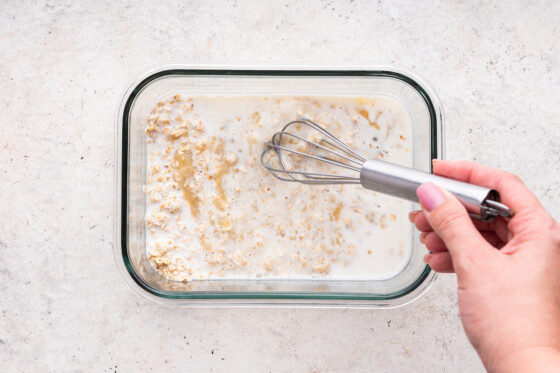 A woman's hand whisking the oatmeal finger mixture together.