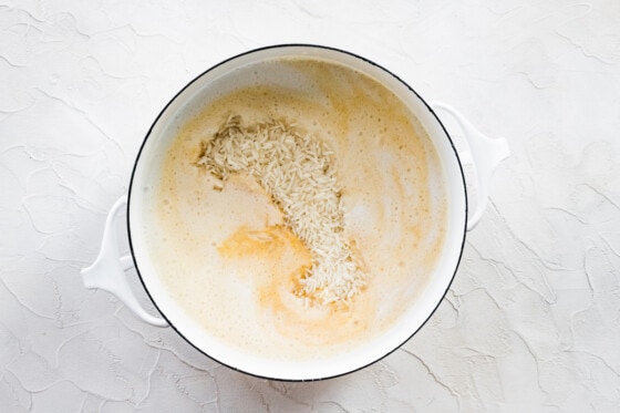 Pumpkin rice in a large white pot before being cooked.