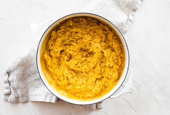 Pumpkin rice in a large white pot after being cooked.