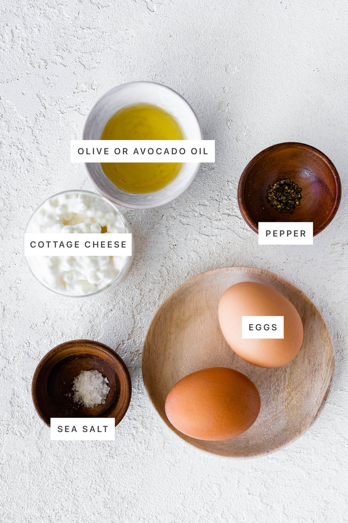 Ingredients measured out to make Cottage Cheese Eggs: olive oil, salt, pepper, cottage cheese and eggs.