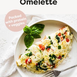 Egg white omelette made with veggies and topped with parmesan on a plate.