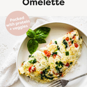 Egg white omelette made with veggies and topped with parmesan on a plate.