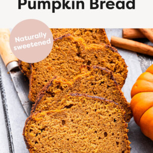 Slices of pumpkin bread next to a pumpkin, cinnamon sticks and a knife.