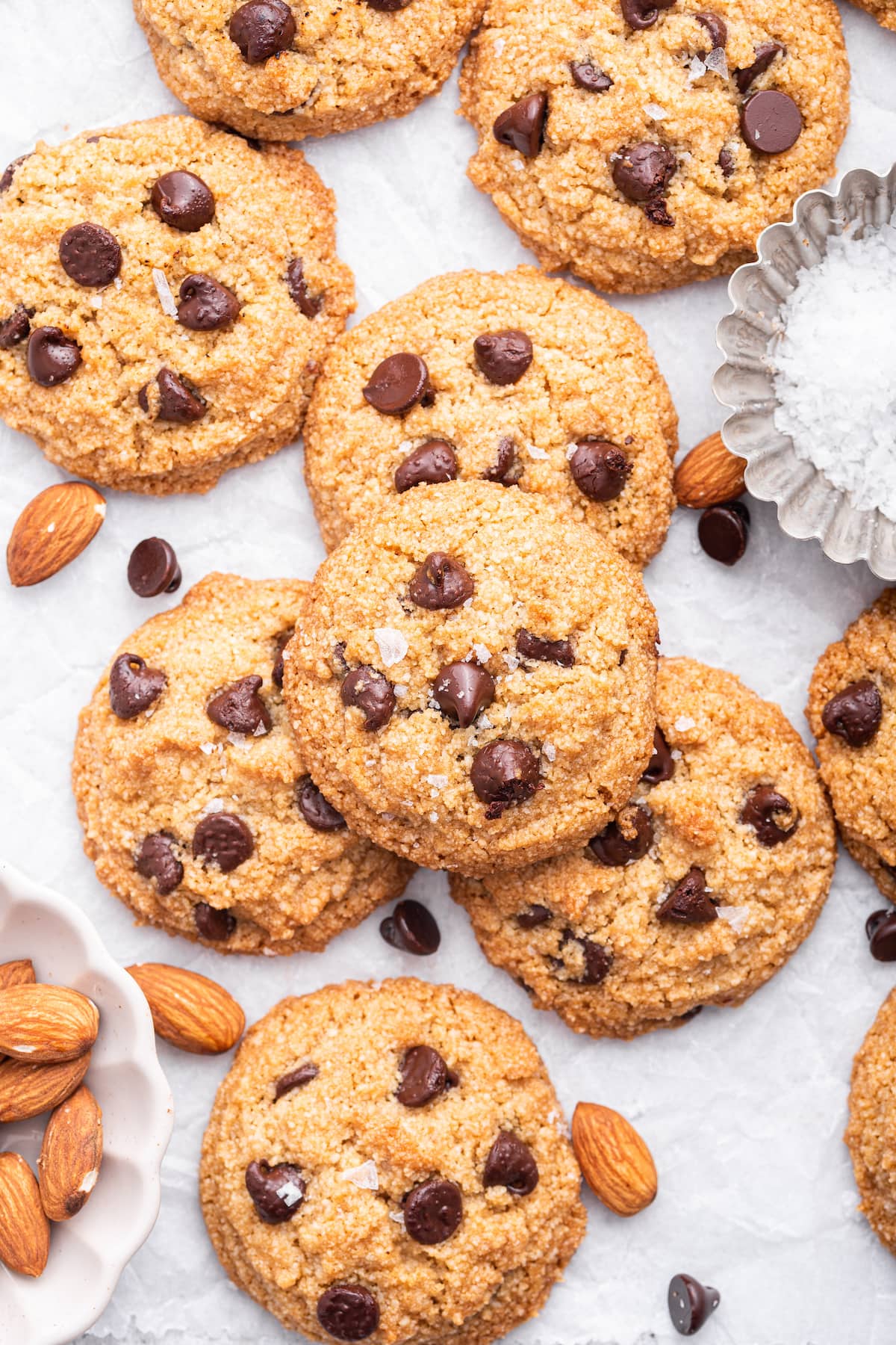 Multiple almond flour chocolate chip cookies on parchment paper.