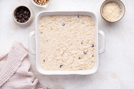 Almond joy baked oatmeal in a square baking dish before being baked.