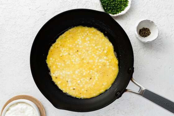 Eggs and cottage cheese being cooked in a skillet.