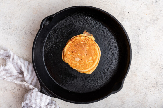 A crisp golden, brown, cottage cheese pancake in a cast iron skillet.