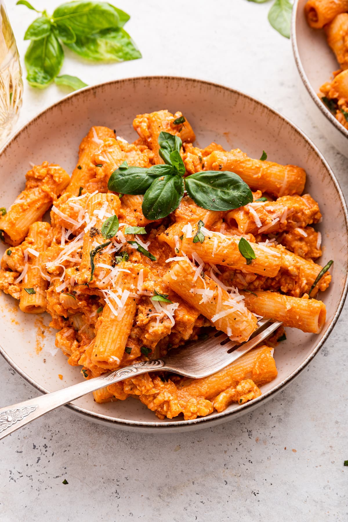 Cottage cheese pasta garnished with fresh basil and parmesan cheese in a bowl.