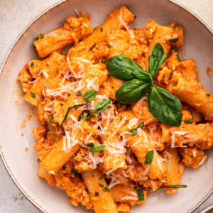 Cottage cheese pasta garnished with fresh basil and parmesan cheese in a bowl.