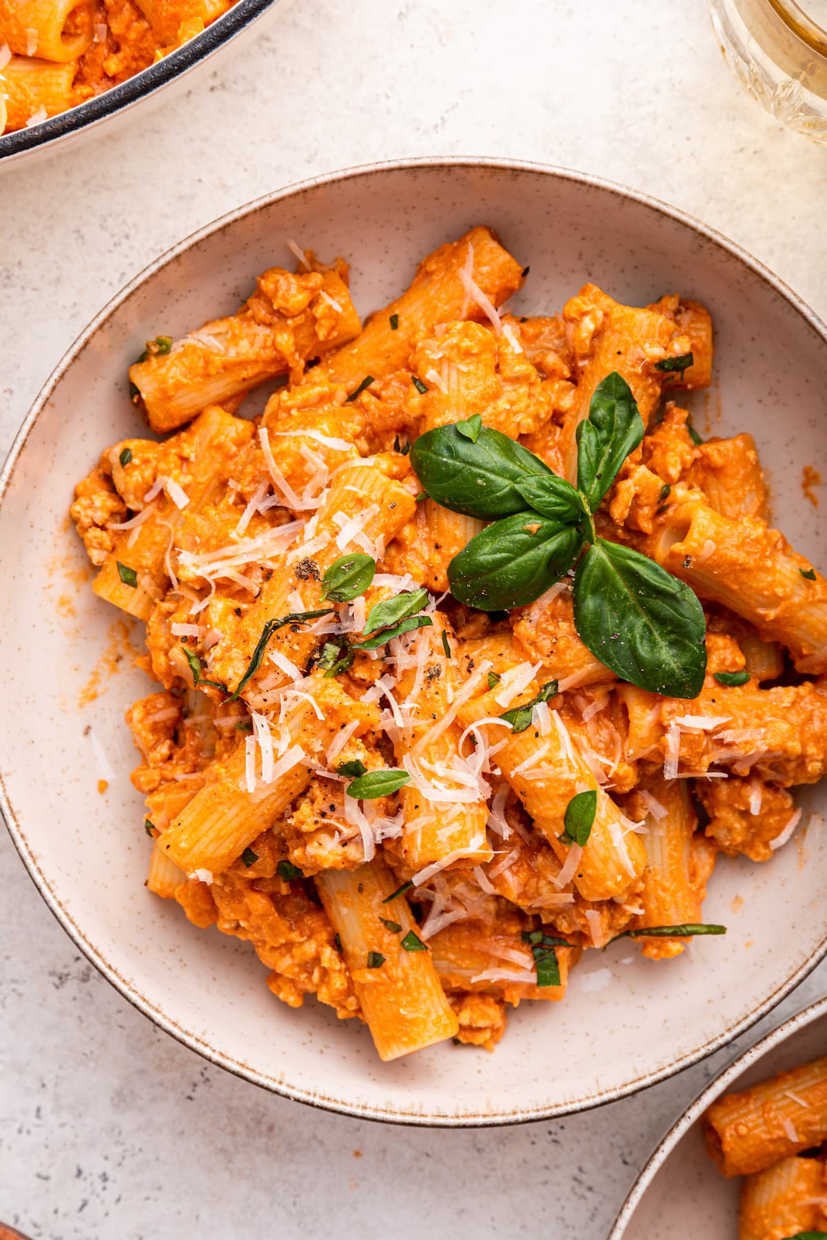 Cottage cheese pasta garnished with fresh basil and parmesan cheese in a bowl.