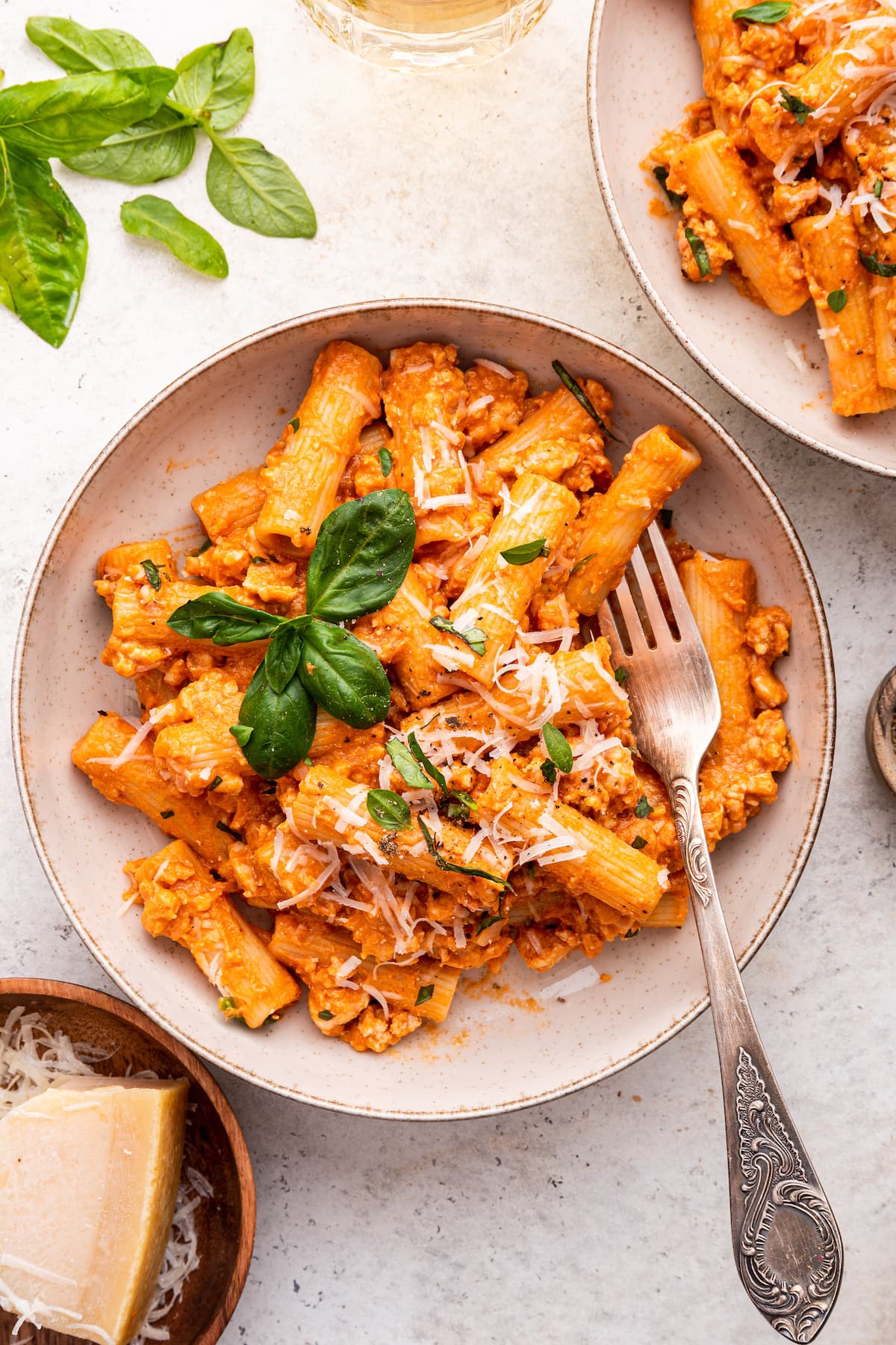Cottage cheese pasta garnished with fresh basil and parmesan cheese in a bowl.