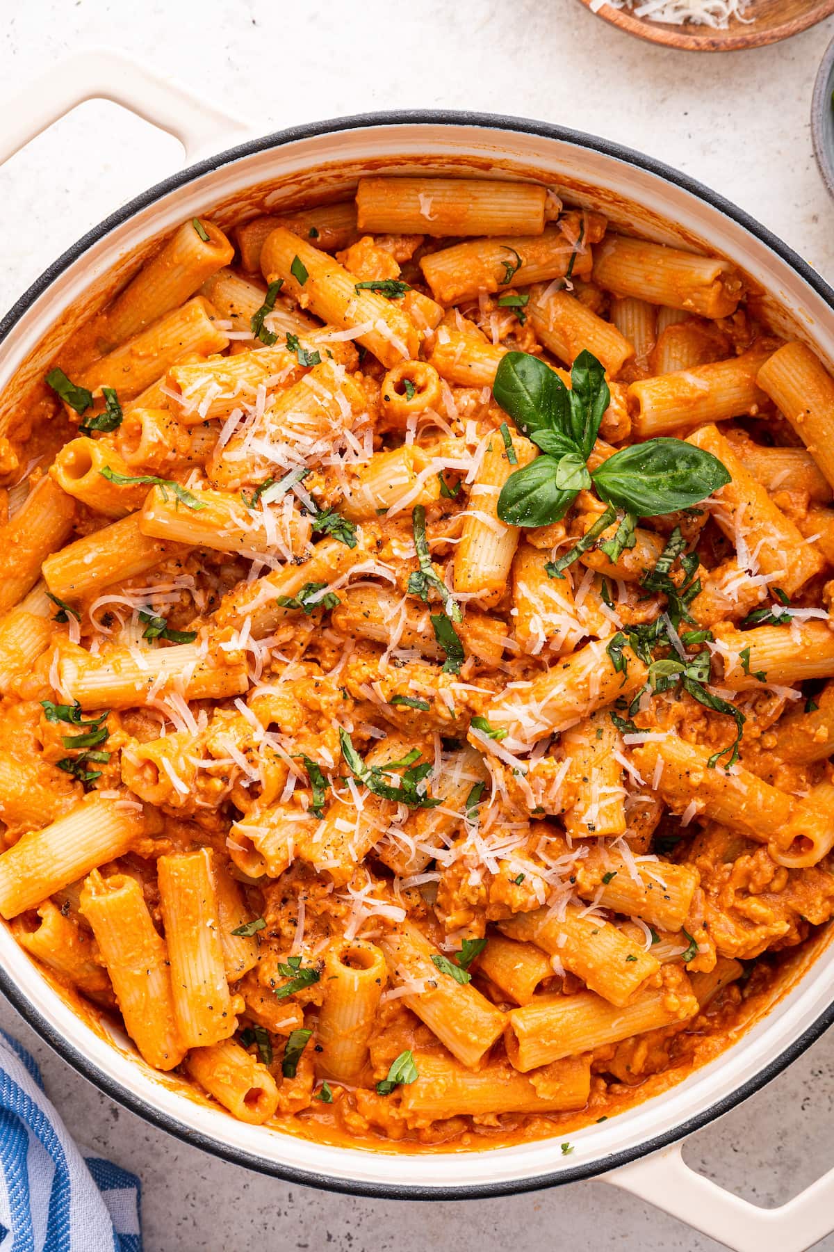 Cottage cheese pasta in a large bowl garnished with fresh basil and parmesan cheese.