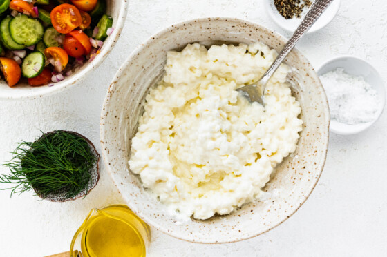 Cottage cheese in a large bowl with a metal spoon.