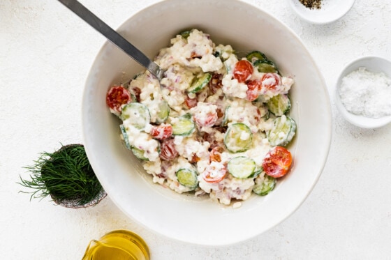 Cottage cheese salad mixed together in a large bowl with a metal serving spoon.