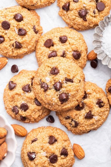 Multiple almond flour chocolate chip cookies on parchment paper.