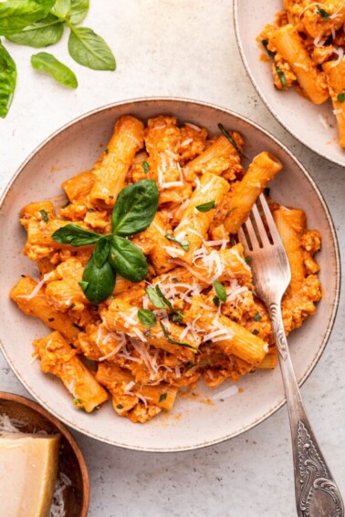 Cottage cheese pasta garnished with fresh basil and parmesan cheese in a bowl.